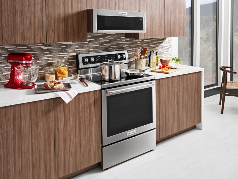 A stainless steel KitchenAid® slide-in range next to prepared dishes A stainless steel KitchenAid® slide-in range next to prepared dishes