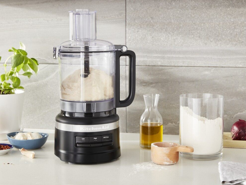 Food processor with dough inside and ingredients on countertop Food processor with dough inside and ingredients on countertop