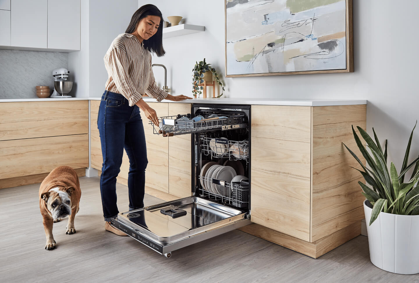 Person picking up dirty bowl to load into dishwasher Person picking up dirty bowl to load into dishwasher
