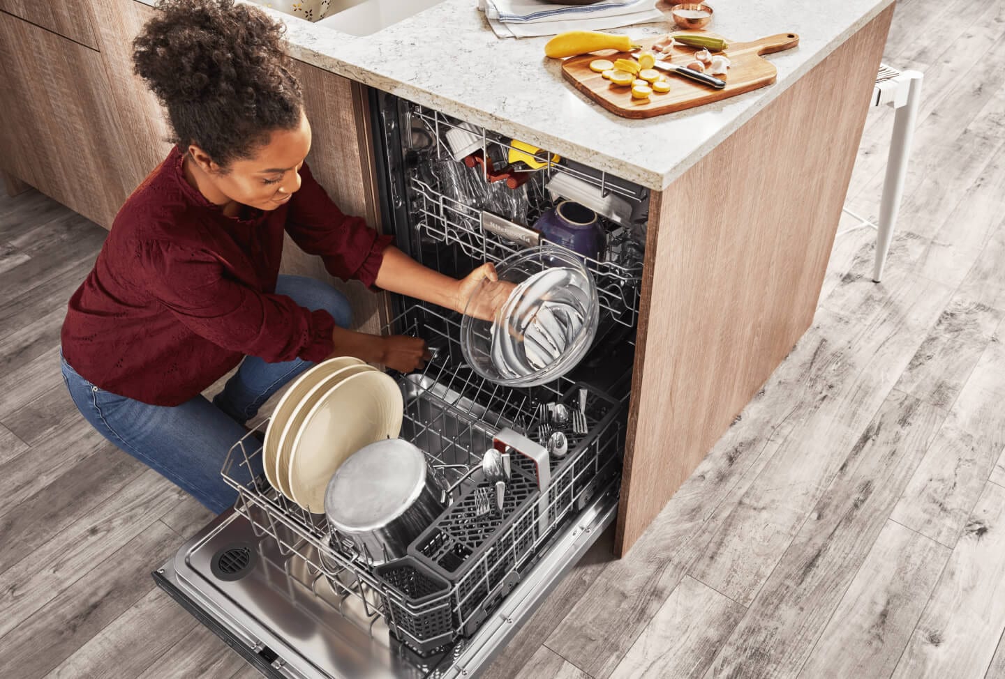 Person placing a clear glass mixing bowl into the dishwasher