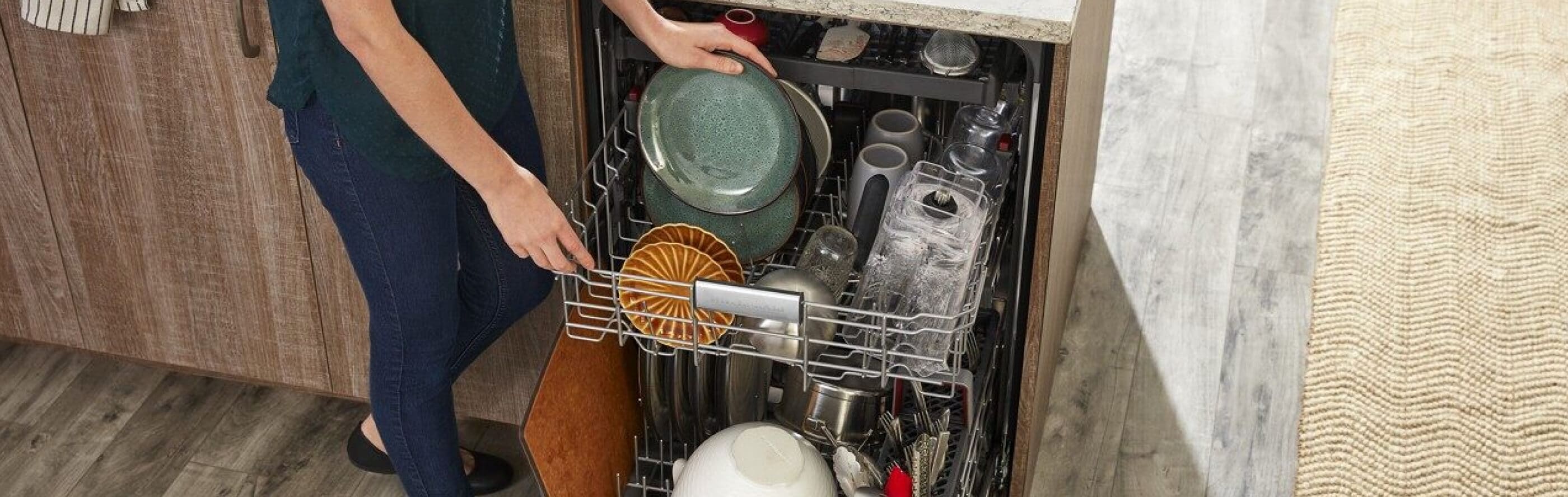 Person loading dishes into dishwasher