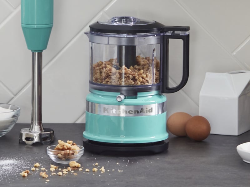 Walnuts inside a teal KitchenAid® food chopper