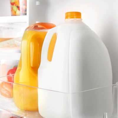Milk and orange juice inside a refrigerator
