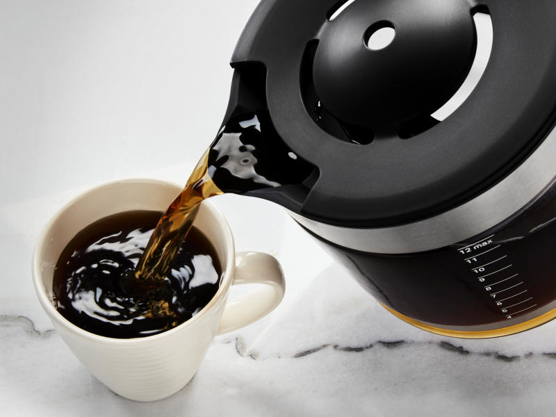 Coffee being poured into a ceramic mug