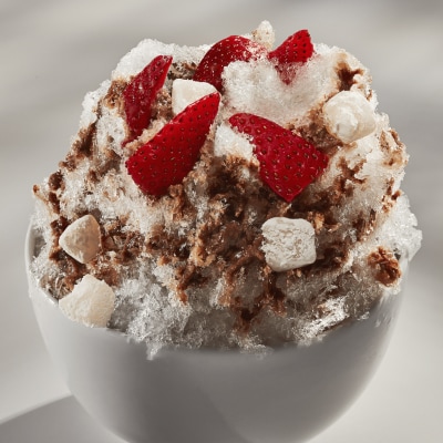 Shaved ice dessert with chopped fruit, nuts and tteok