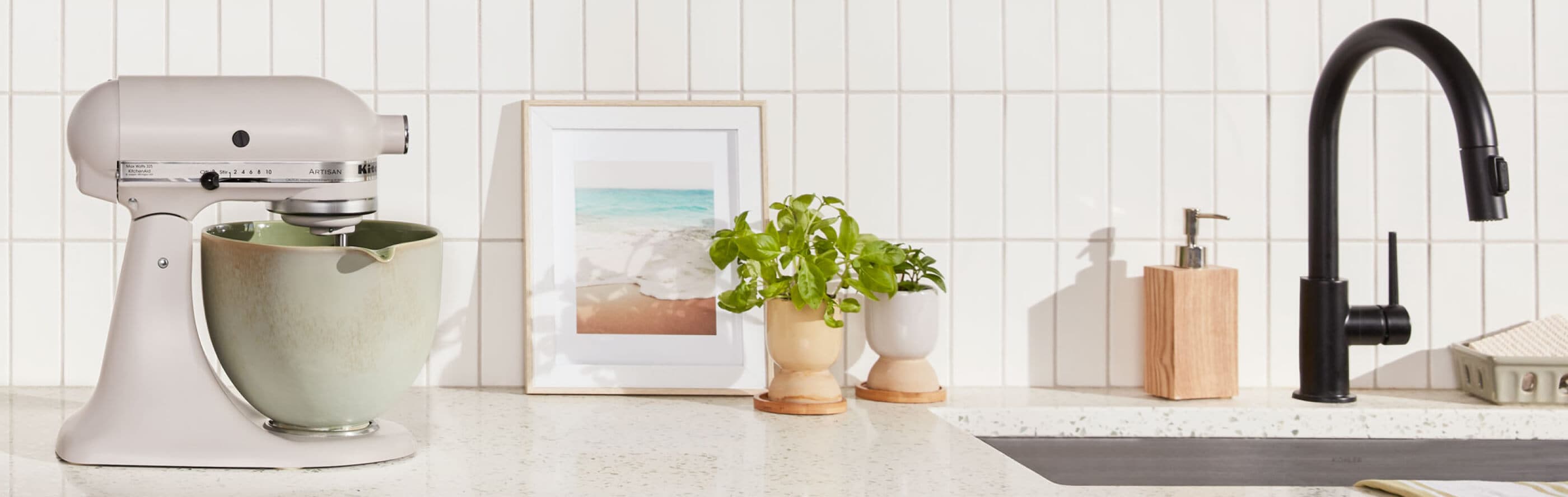 Beige KitchenAid® stand mixer with distressed green mixer bowl on granite countertop