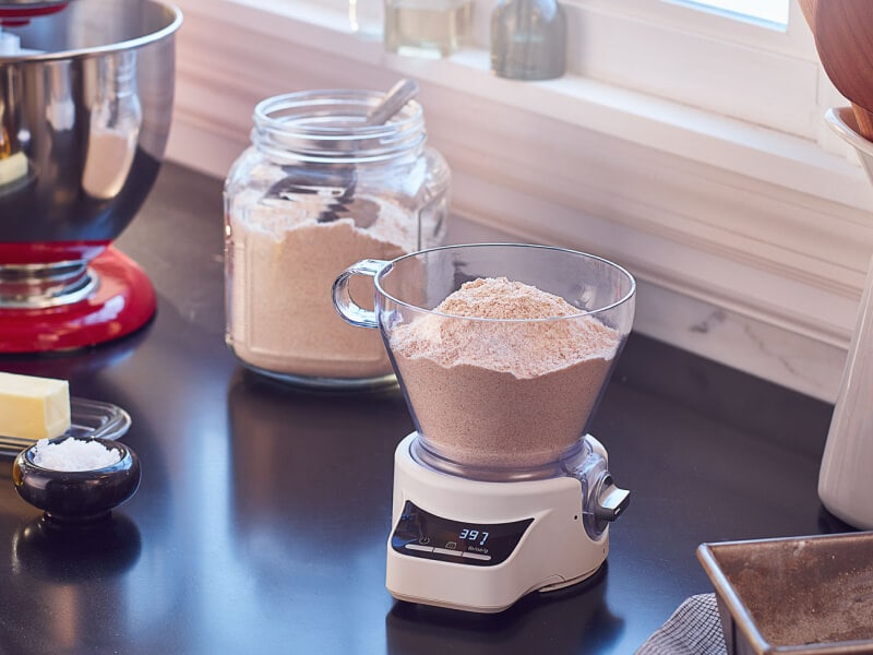 Flour sitting in a food scale on a black countertop