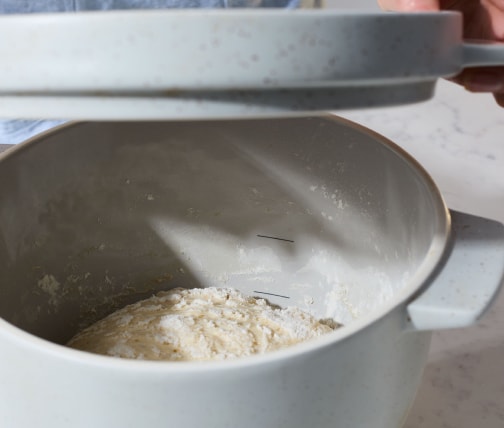 Person adding Bread Bowl lid to proof dough Person adding Bread Bowl lid to proof dough