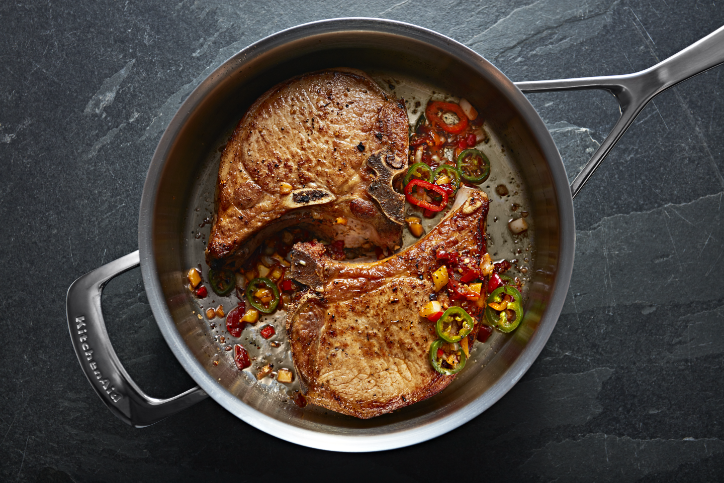 Two steaks inside a stainless steel pan Two steaks inside a stainless steel pan