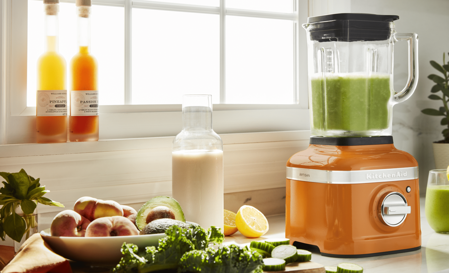 Orange KitchenAid® blender next to fresh kale Orange KitchenAid® blender next to fresh kale