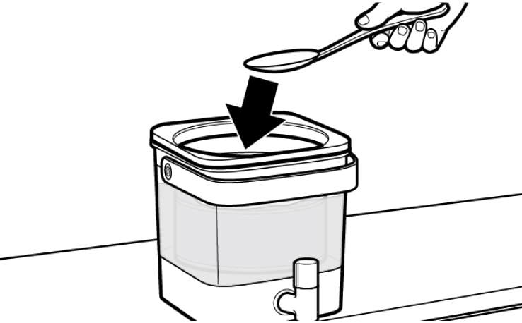 Hand using spoon to submerge cold brew coffee grounds in water