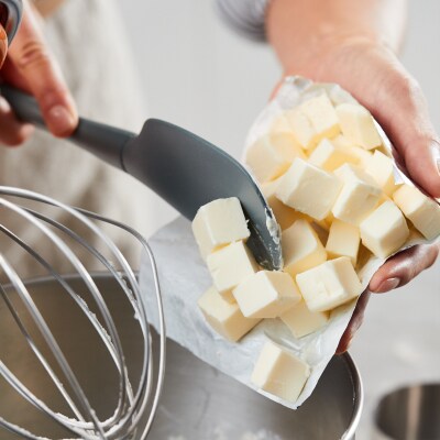 Person adding cubed butter into a KitchenAid® stand mixer bowl