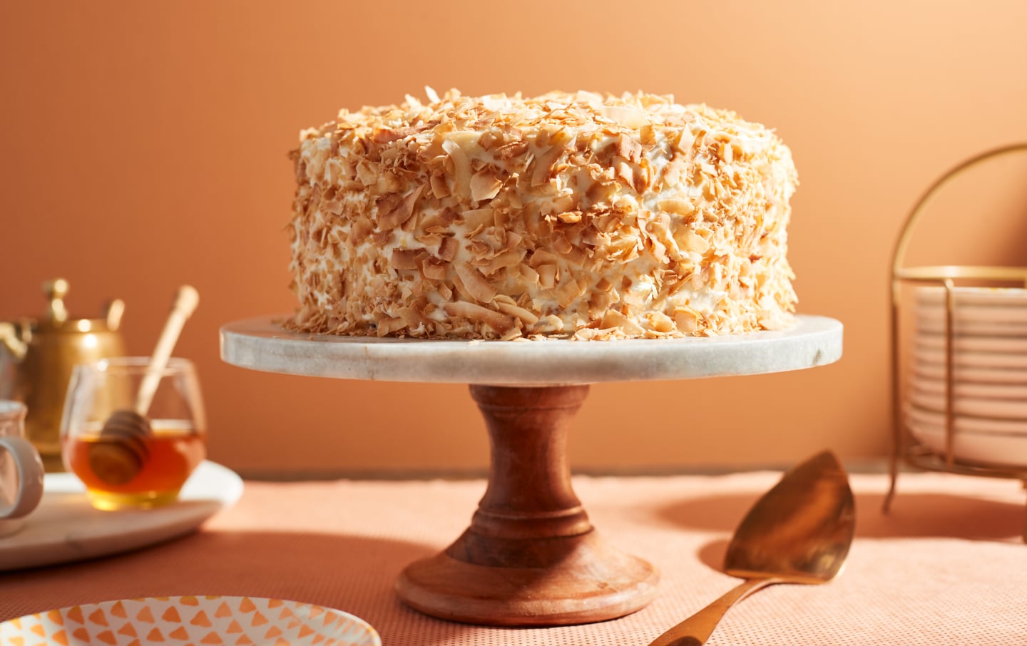 Cake covered in toasted coconut flakes on a cake stand Cake covered in toasted coconut flakes on a cake stand