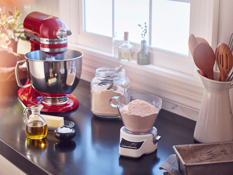 Red KitchenAid® stand mixer next to a food scale with flour