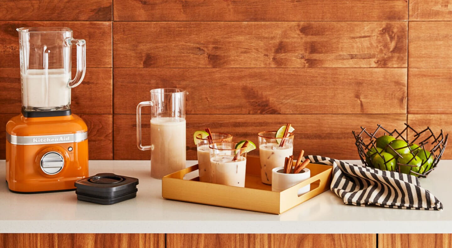 KitchenAid® blender next to a drink tray of blended drinks