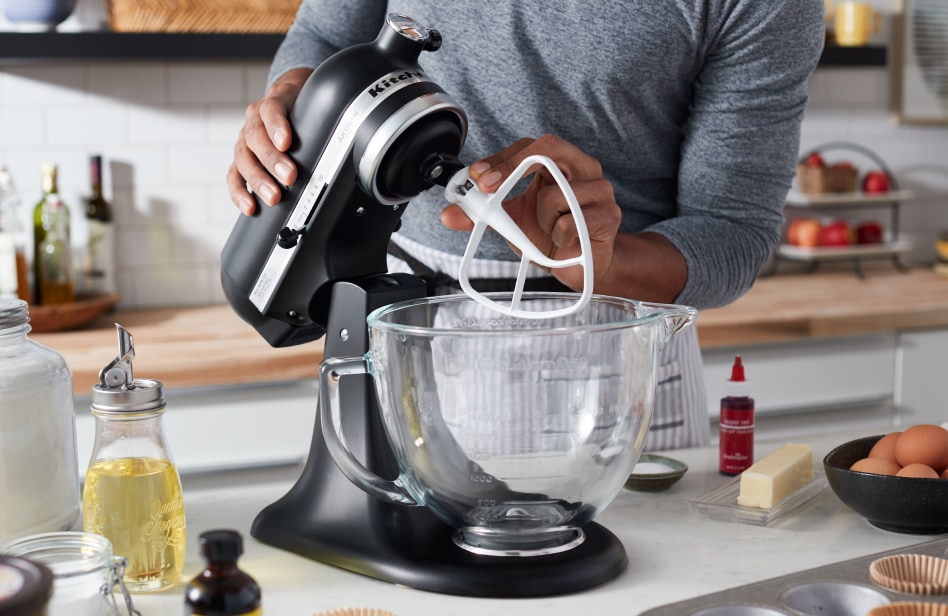 A KitchenAid® tilt-head stand mixer next to ingredients for making a cake A KitchenAid® tilt-head stand mixer next to ingredients for making a cake