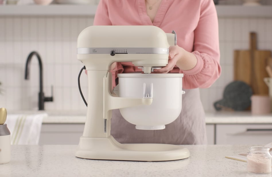 Woman Securing ice cream maker attachment to stand mixer Woman Securing ice cream maker attachment to stand mixer