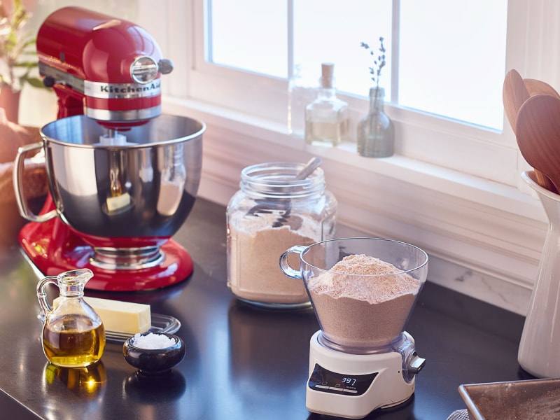 Red KitchenAid® stand mixer on countertop with baking ingredients Red KitchenAid® stand mixer on countertop with baking ingredients