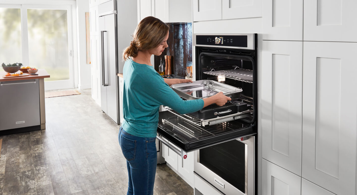 Person prepping their KitchenAid® oven to make ribs. Person prepping their KitchenAid® oven to make ribs.