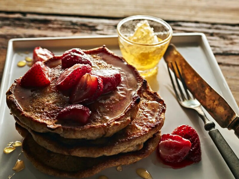 Lemon ricotta rye pancakes topped with sliced strawberries