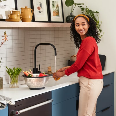 Woman rinsing ingredients in a sink