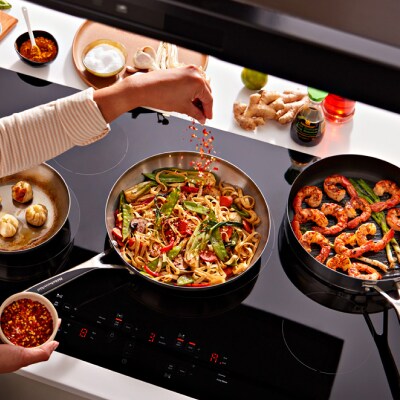 Person sauteing vegetables in a pan