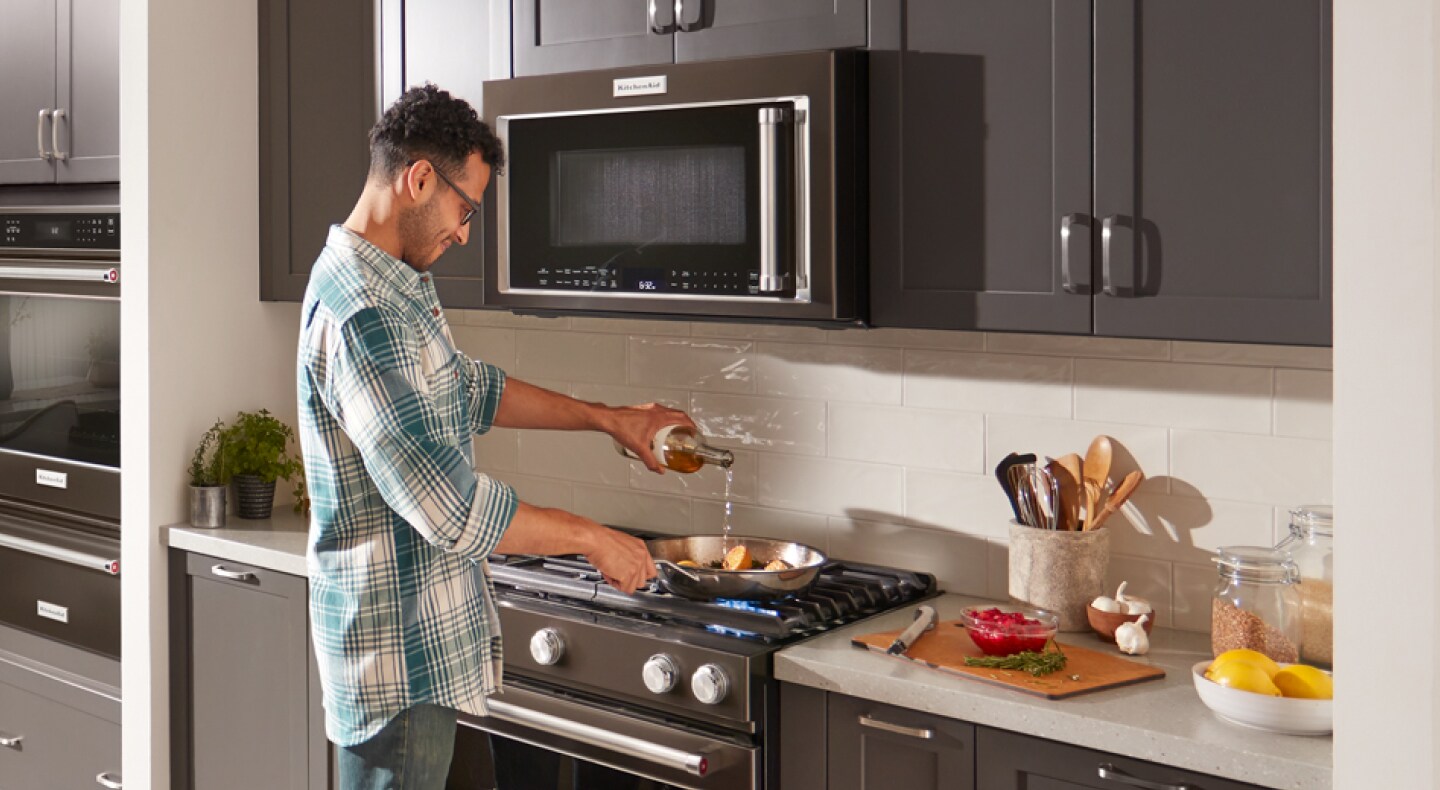 Person cooking on a KitchenAid® gas range Person cooking on a KitchenAid® gas range