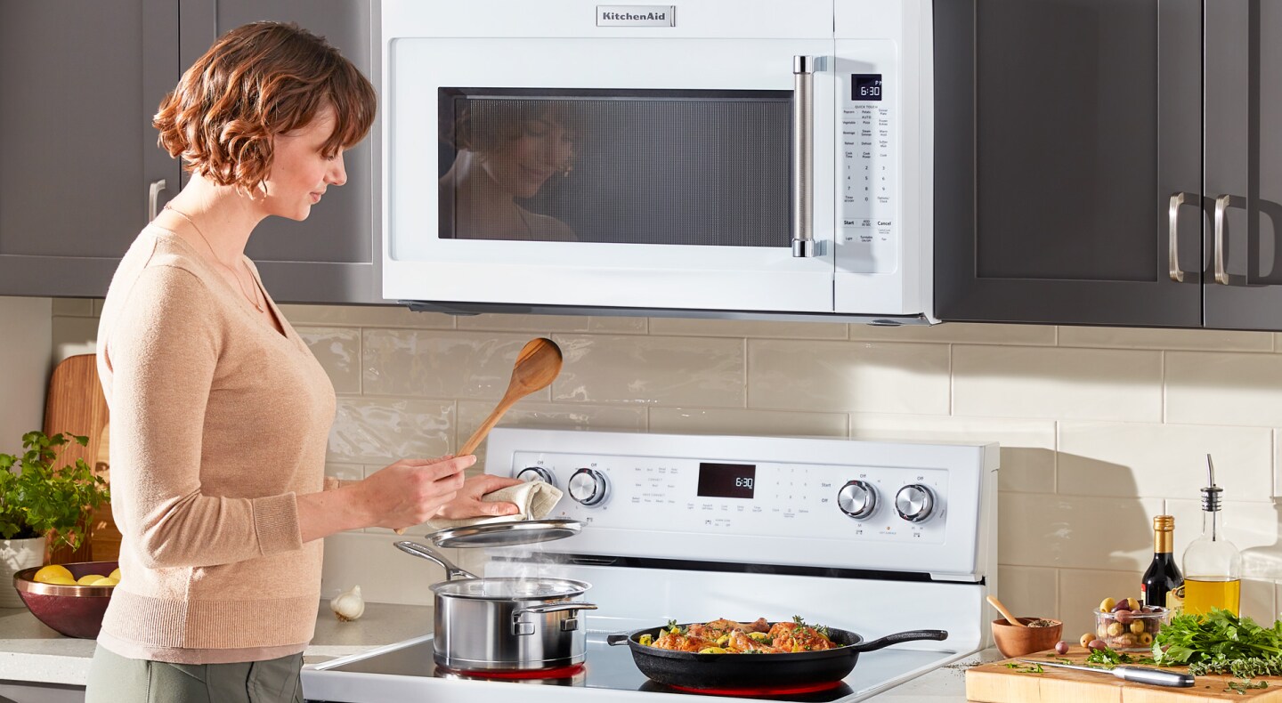 Woman cooking on a KitchenAid range Woman cooking on a KitchenAid range