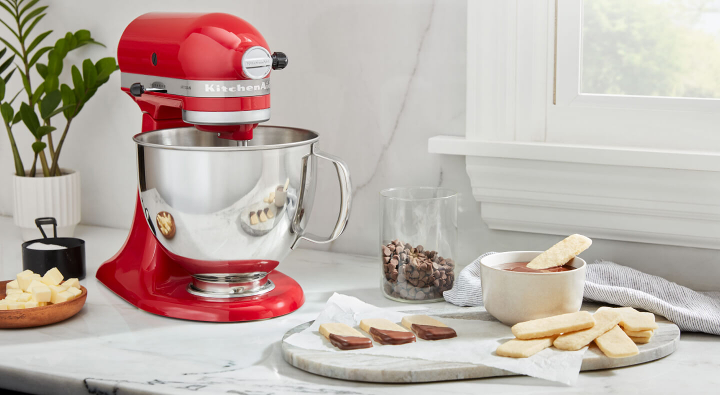 A red KitchenAid® stand mixer and a prepared dessert on a countertop A red KitchenAid® stand mixer and a prepared dessert on a countertop