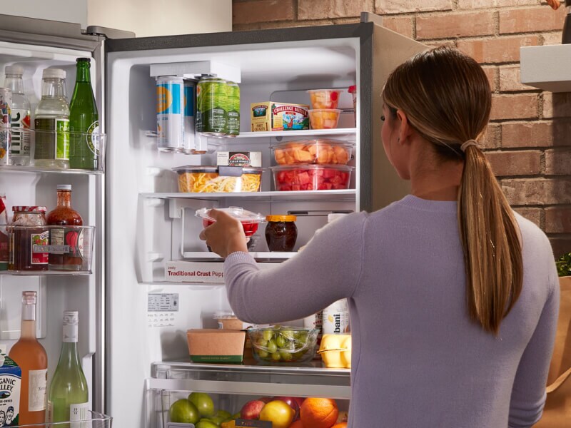 Person grabbing ingredients from the refrigerator