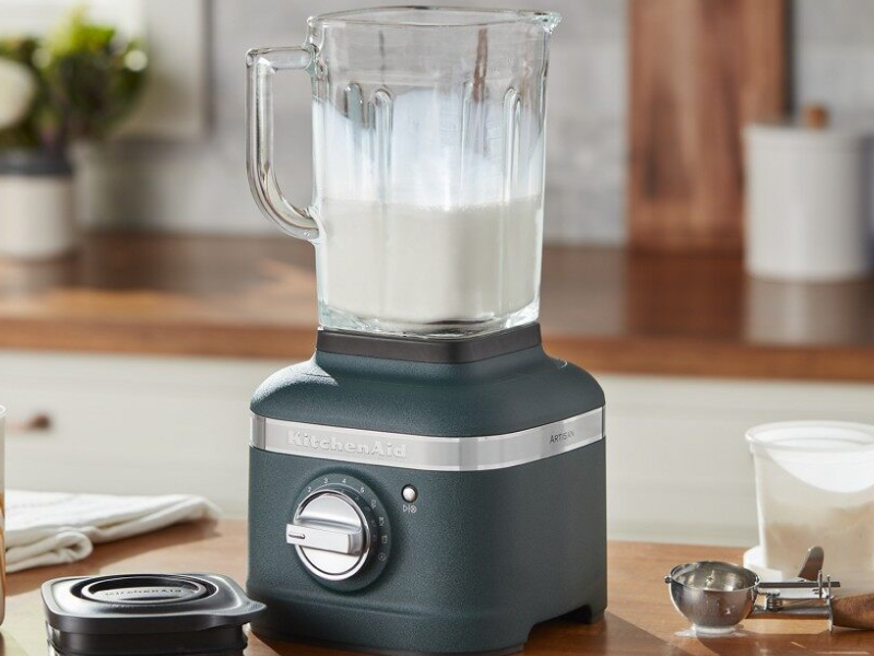 Black KitchenAid® blender filled with milk on countertop with top removed Black KitchenAid® blender filled with milk on countertop with top removed