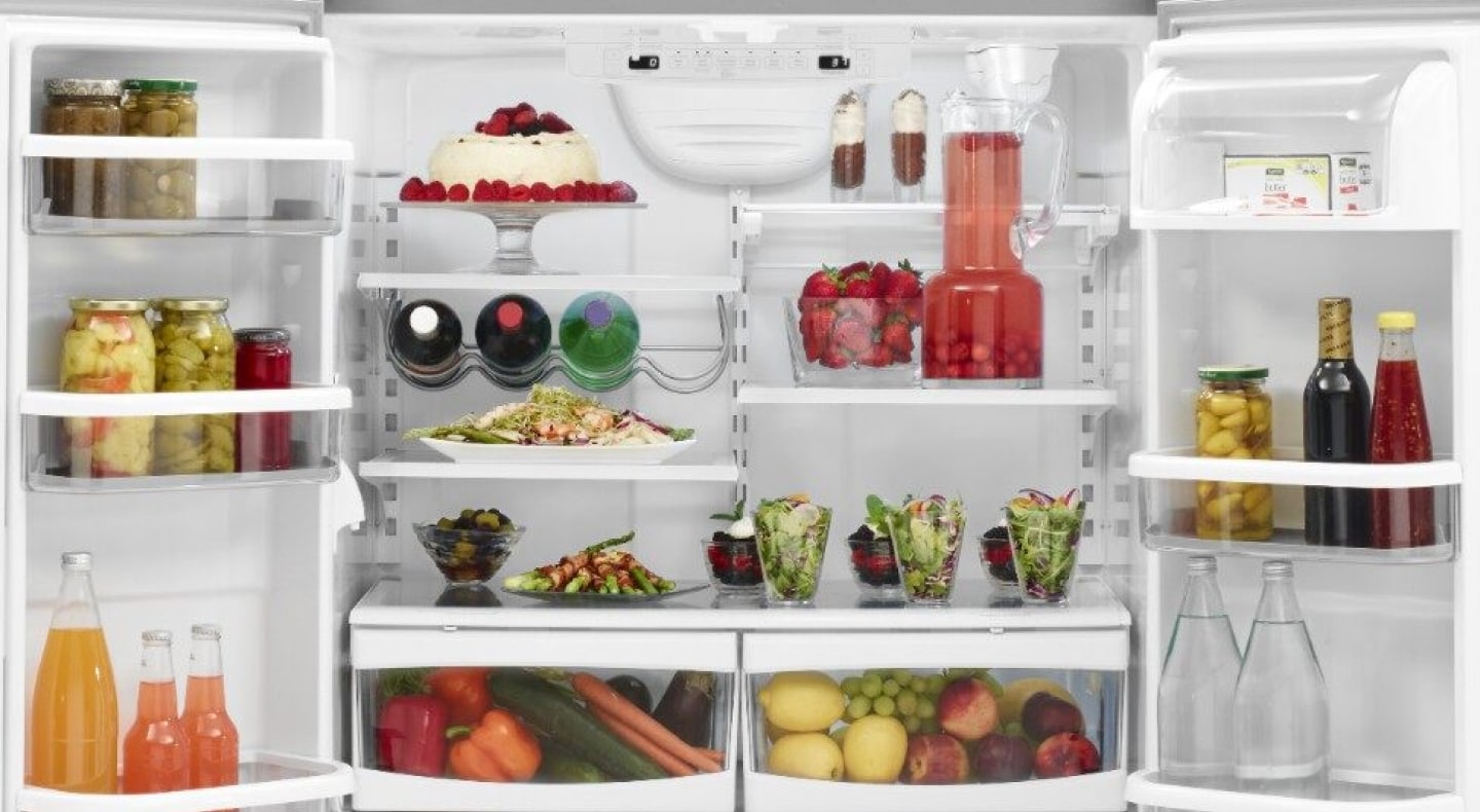 An organized refrigerator with vegetables, fruit, jars, bottled drinks and cake. An organized refrigerator with vegetables, fruit, jars, bottled drinks and cake.