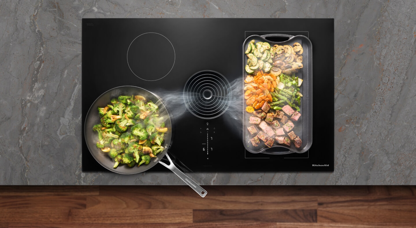 Vegetables cooking on a KitchenAid brand cooktop