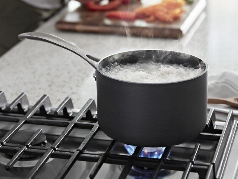 Water boiling in a saucepan on a gas stovetop over a flame