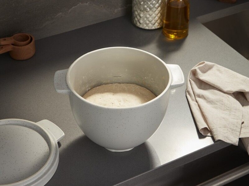 Bread dough proofing in a bread bowl on a countertop