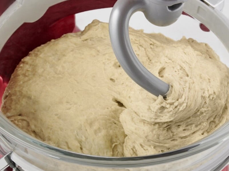 Close-up of a dough hook inside of bread dough in a stand mixer bowl Close-up of a dough hook inside of bread dough in a stand mixer bowl