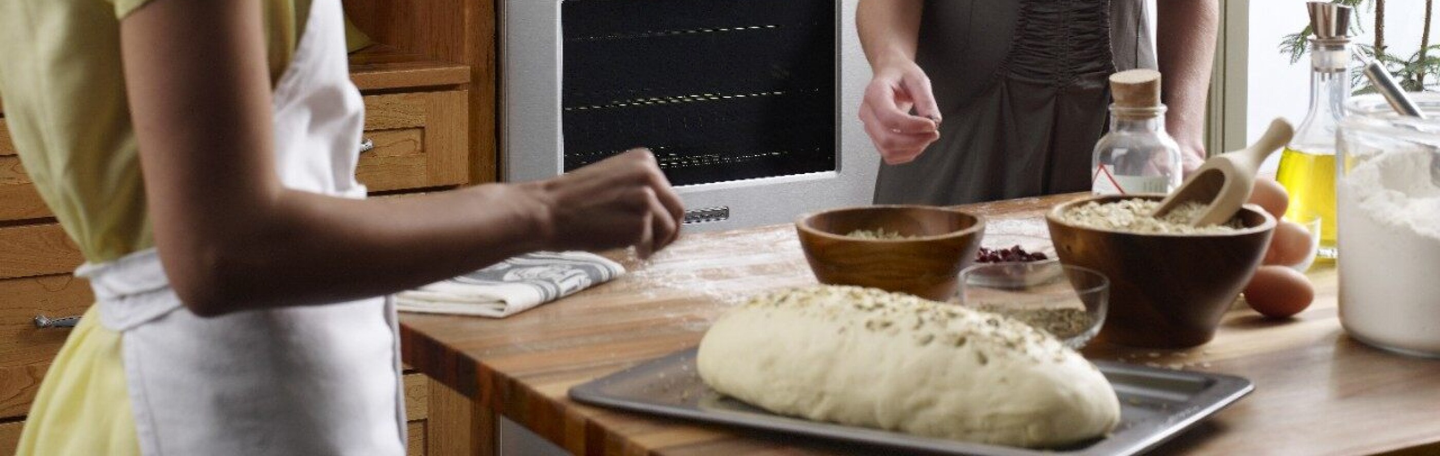 Person garnishing bread dough on a cookie sheet
