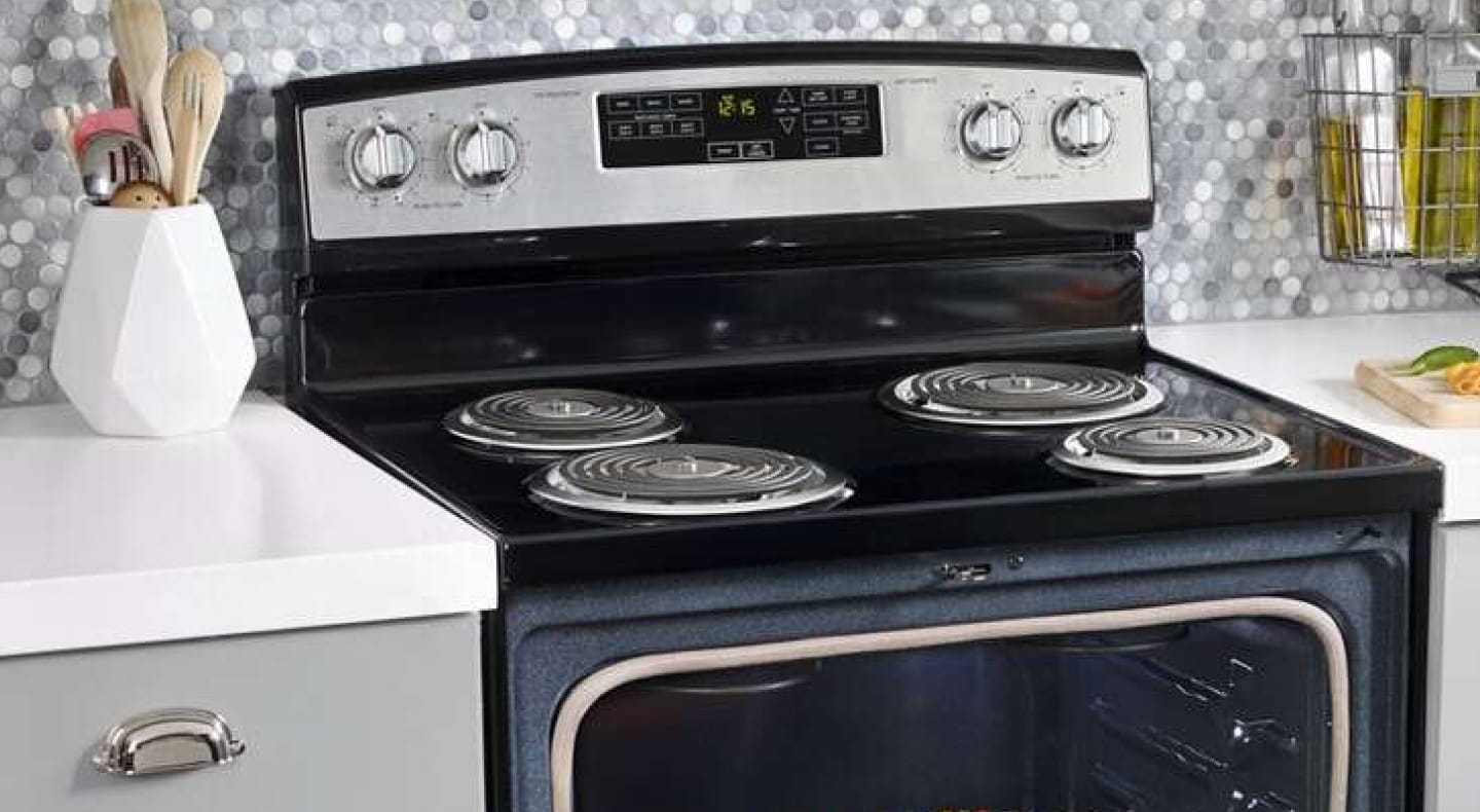 Black electric stove with coil burners in front of a gray and white backsplash Black electric stove with coil burners in front of a gray and white backsplash