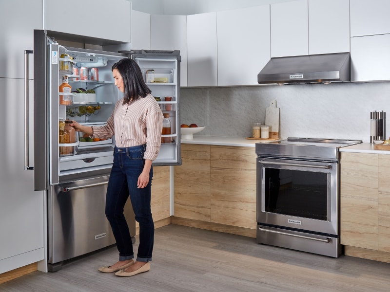 Person removing item from KitchenAid® refrigerator Person removing item from KitchenAid® refrigerator