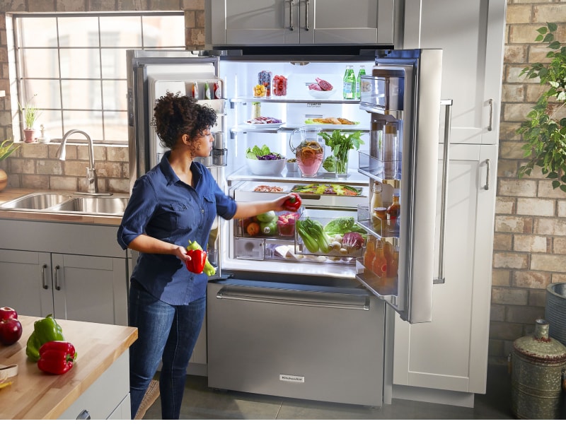 Person removing produce from KitchenAid® refrigerator Person removing produce from KitchenAid® refrigerator