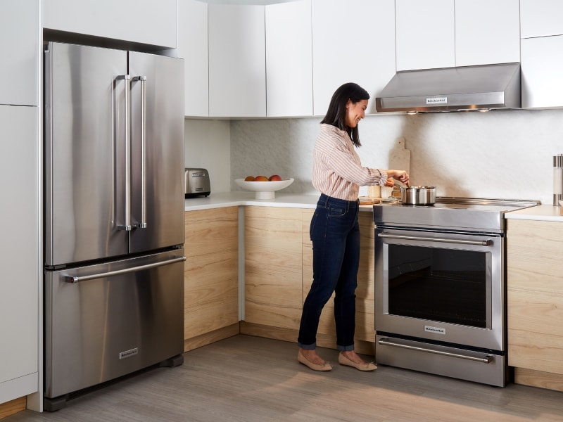 Person cooking at a KitchenAid® range Person cooking at a KitchenAid® range