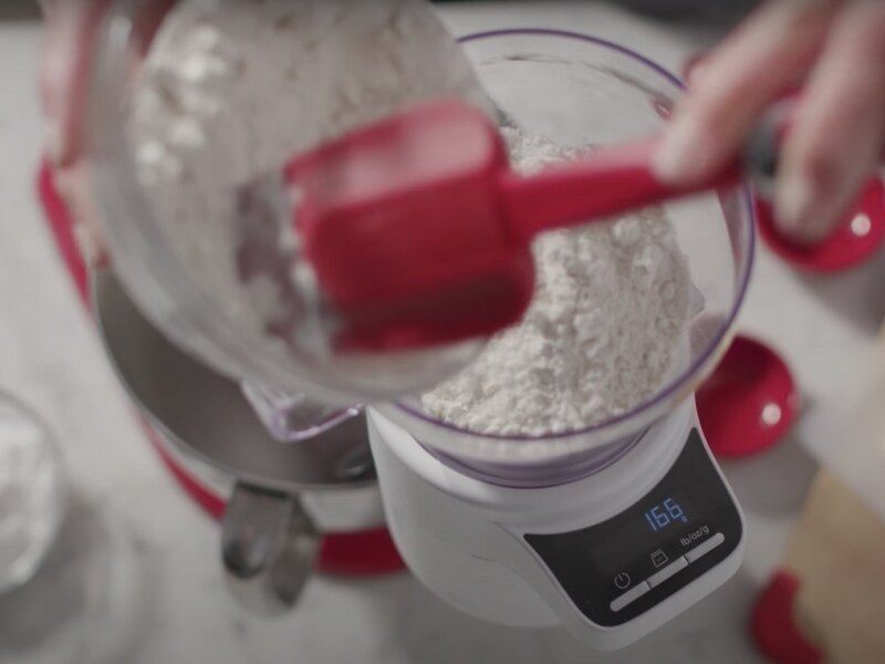 Flour being scooped into a bowl on the scale attachment