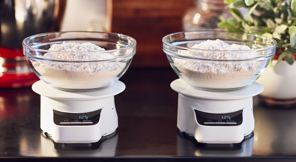 Two bowls of flour on two scales Two bowls of flour on two scales