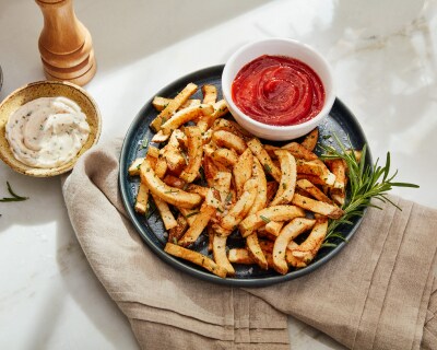 A plate of french fries with aioli and ketchup