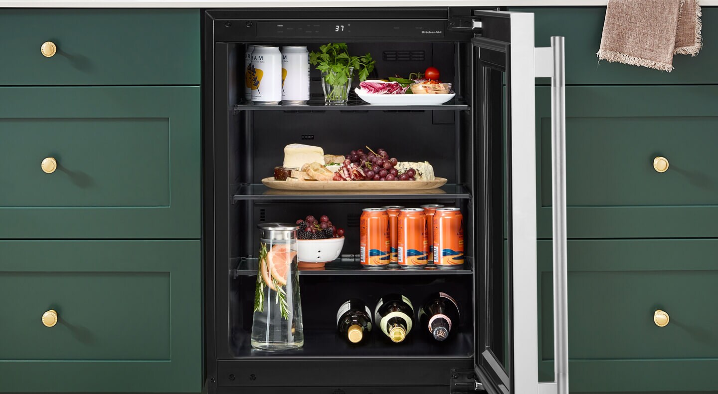 Open undercounter refrigerator with beverages and charcuterie inside