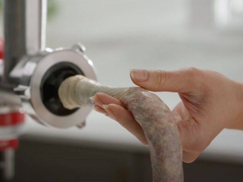 Person feeding ground meat into the casing
