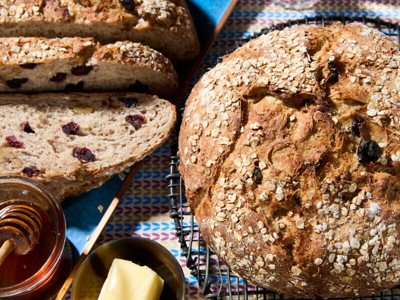 Loaf of bread with sliced bread and honey next to it
