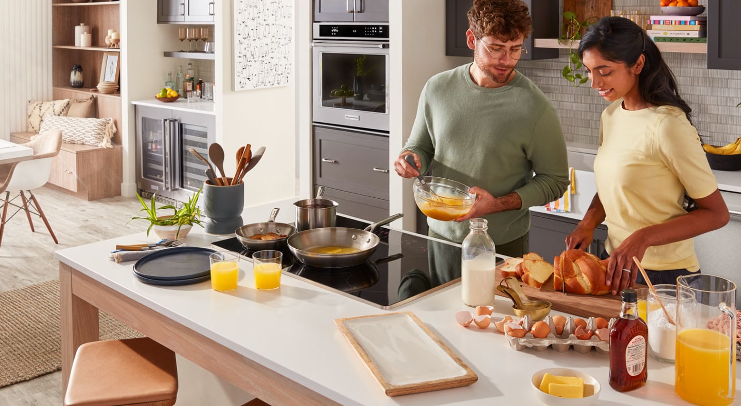 Two people cooking at a kitchen island