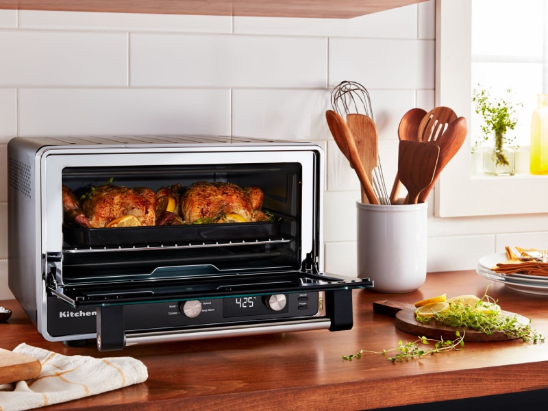 Two whole roasted chickens and greens cooked inside a KitchenAid® countertop oven Two whole roasted chickens and greens cooked inside a KitchenAid® countertop oven