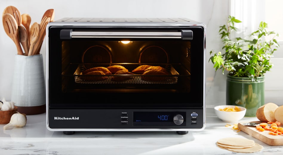 Empanadas cooking inside a black KitchenAid® countertop oven Empanadas cooking inside a black KitchenAid® countertop oven